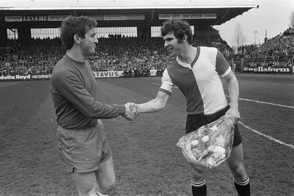 Feyenoord spits Willem van Hanegem (r) krijgt bloemen uit handen van Ajaxspeler [...]. Foto: fotograaf onbekend / Anefo, Nationaal Archief (CC0).