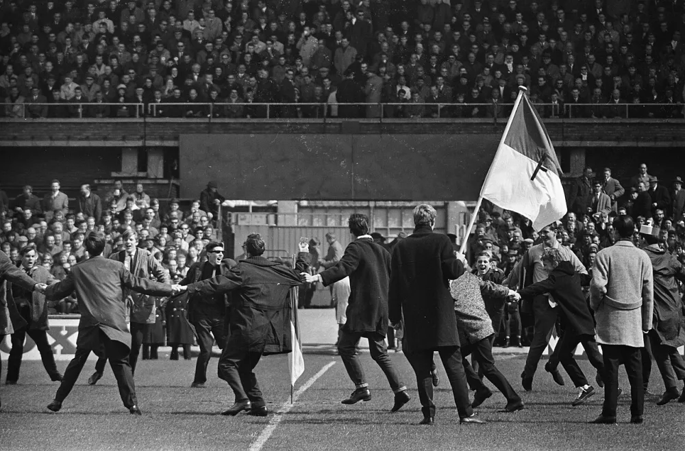 Ajax tegen Feyenoord 1-1 in Olympisch Stadion , supporters Feyenoord met vlag maken vreugdedans. Foto: Joost Evers / Anefo, Nationaal Archief (CC0).