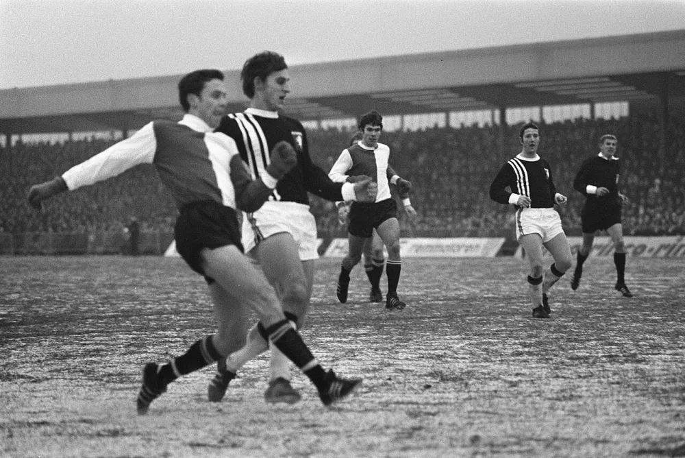 Voetbal. FC Twente tegen Feijenoord 1-1. Spelmoment, Ove Kindvall in duel met Kees van Ierssel (Twente). In de achtergrond Willem van Hanegem en Eddy Achterberg (Twente). Rechts scheidsrechter…. Foto: Rob Mieremet / Anefo, Nationaal Archief (CC0).