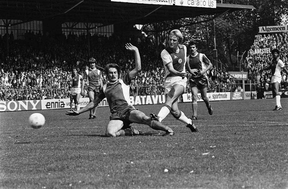 Ajax tegen Feyenoord 4-1; Willem Kieft scoort voor Ajax Iwan Nielsen is te laat. Foto: Hans van Dijk / Anefo, Nationaal Archief (CC0).
