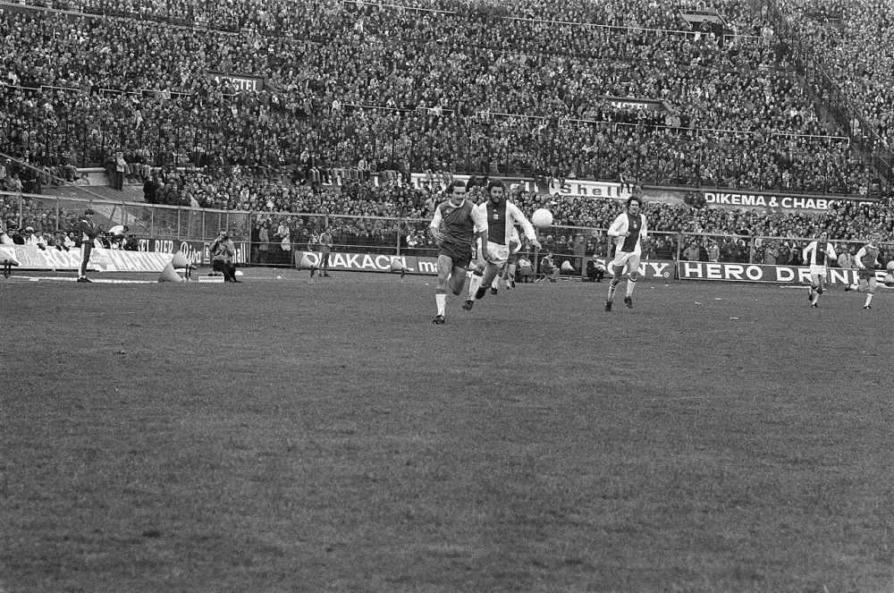 Een duel om de bal op het middenveld, met o.a. Ajacied Hans Erkens. Ajax- verdediger Johnny Dusbaba kijkt toe. Foto: fotograaf onbekend / Anefo, Nationaal Archief (CC0).