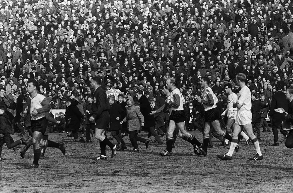 Ajax tegen Feijenoord 1-3. Feijenoord krijgt penalty, publiek stroomt veld op, v.l.n.r. Kreijermaat, scheidsrechter Leo Horn, Moulijn, Kruiver, Van der Gijp , Swart en H. Groot. Foto: Harry Pot / Anefo, Nationaal Archief (CC0).
