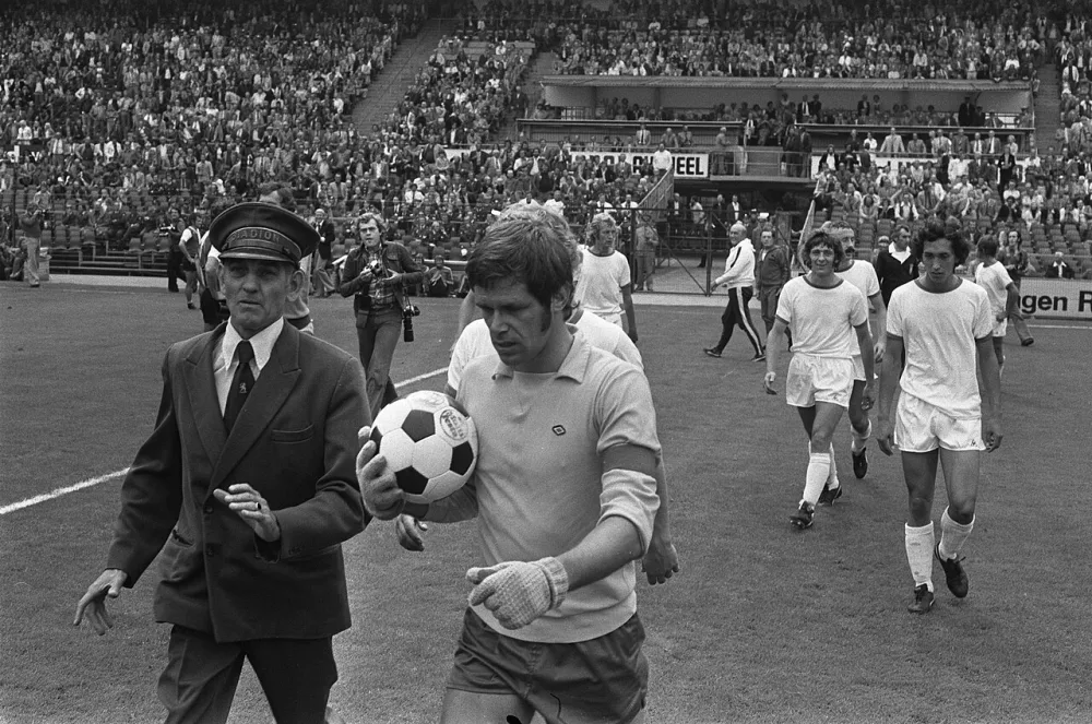 Uit protest tegen een omstreden strafschop loopt FC Amsterdam keeper Jongbloed met de bal naar de zijlijn, waarvoor hij een kaart krijgt. Foto: fotograaf onbekend / Anefo, Nationaal Archief (CC0).