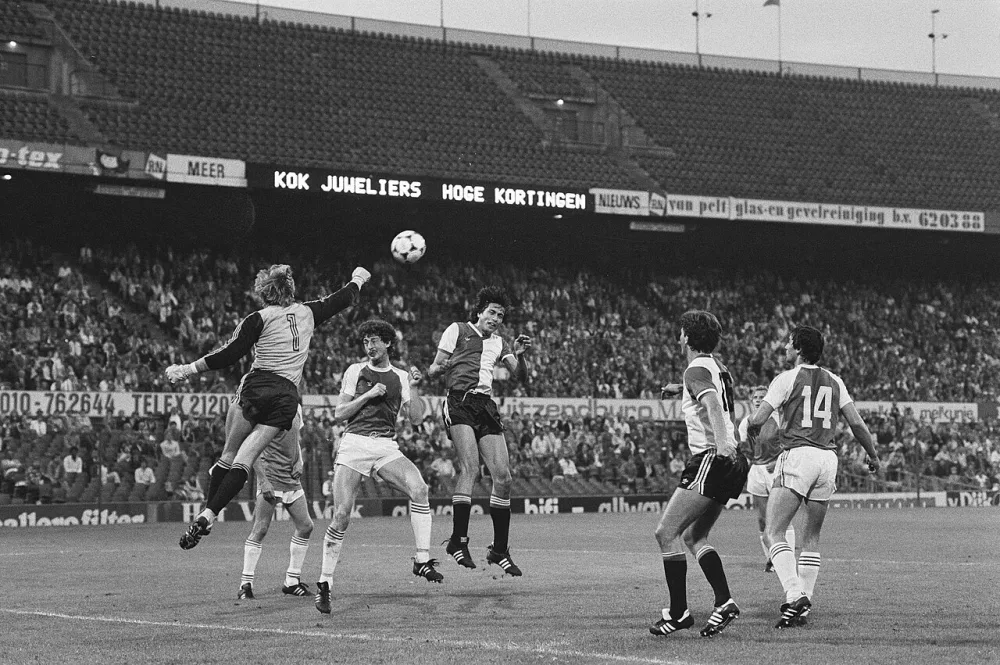 PSV-doelman Pim van Doesburg stompt de bal weg, rechts Feyenoord-aanvaller Karel Bouwens en Ernie Brandts. Foto: Marcel Antonisse / Anefo, Nationaal Archief (CC0).