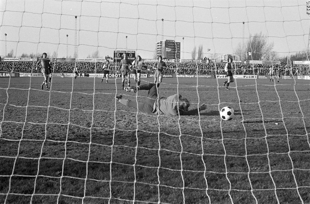 Theo de Jong scoort, doelman Lelieveld duikt naar de bal. Foto: Fotograaf Onbekend / Anefo, Nationaal Archief (CC0).
