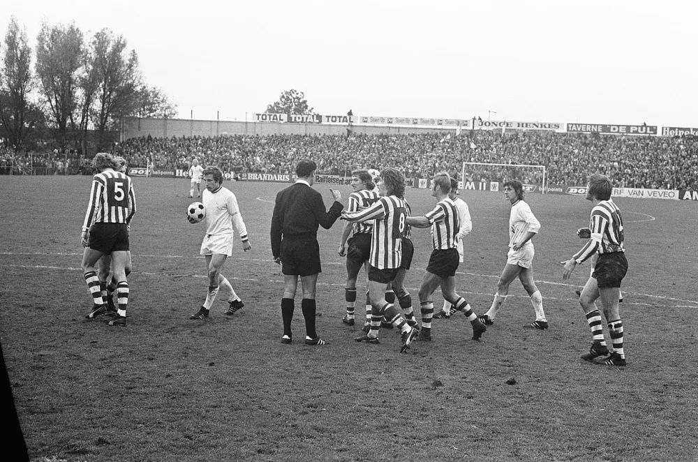 Spelers protesteren bij scheidsrechter Van der Kroft tegen penalty, nummer Schneider scoort uit penalty 1-1. Foto: fotograaf onbekend / Anefo, Nationaal Archief (CC0).