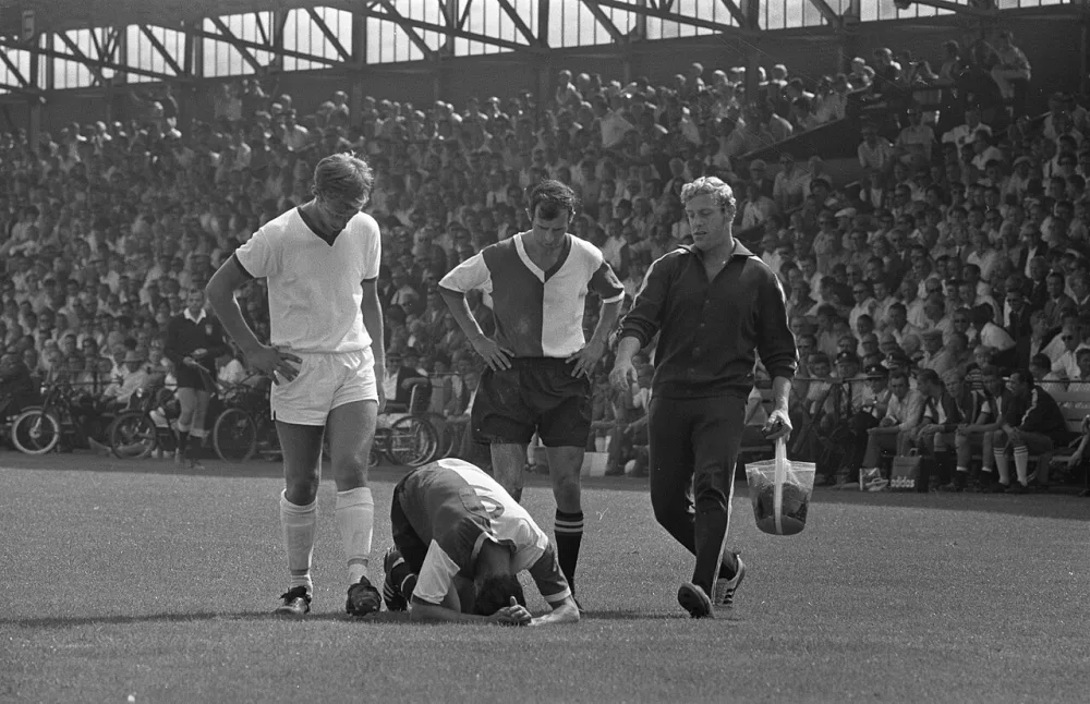 Telstar tegen Feyenoord 1-3. Blessure bij Feyenoord speler (Kindvall?). Moulijn kijkt toe. Verzorger Meyer komt aangesneld. Foto: Joost Evers / Anefo, Nationaal Archief (CC0).