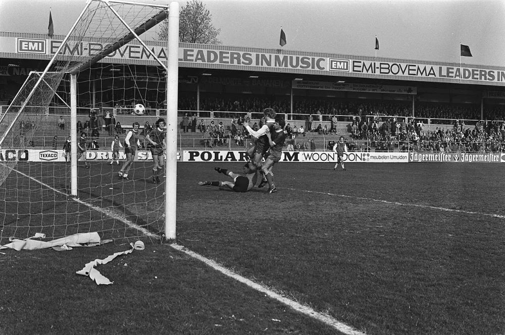 Jansen scoort, De Vries houdt hem vast en keeper Van Dortmundt ligt op de grond. Foto: Hans Peters / Anefo, Nationaal Archief (CC0).