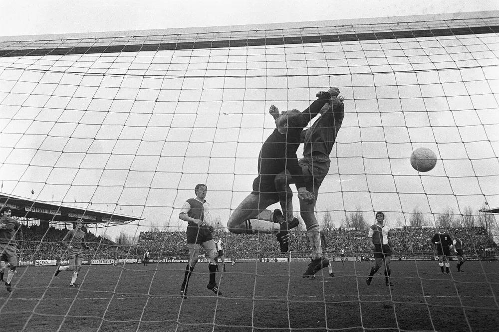 Johan Cruijff scoort voor Ajax, 3-3, Feyenoord keeper Eddy Treijtel in duel met Johan Cruijff. Foto: fotograaf onbekend / Anefo, Nationaal Archief (CC0).
