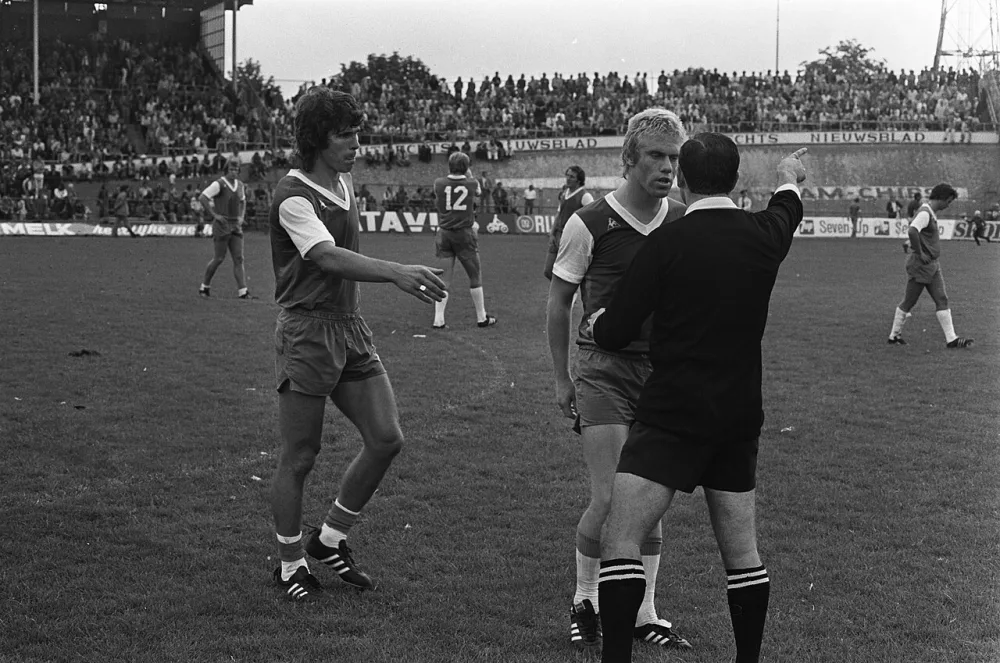 Van Hanegem (l) en Rijsbergen in discussie met scheidsrechter Beck. Foto: fotograaf onbekend / Anefo, Nationaal Archief (CC0).
