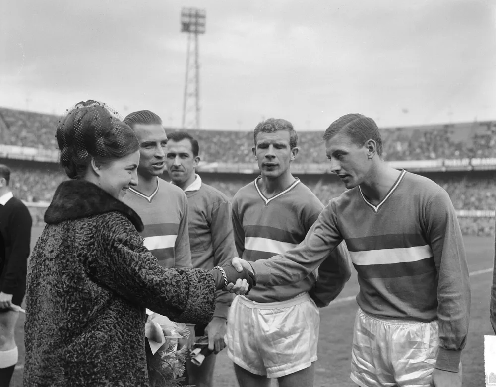 Aktie Dousadj. De spelers van Feyenoord worden aan prinses Margriet voorgesteld, midden Hans Kraay, rechts [Henk Warnas?]. Foto: Joop van Bilsen / Anefo, Nationaal Archief (CC0).