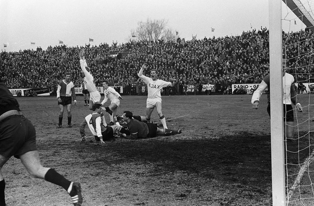 Ajax tegen Feijenoord 1-3. Henk Groot maakt voor Ajax het eerste en enige doelpunt v.l.n.r. Kraay, H. Groot , Petersen, Cees Groot , op grond Veldhoen, Kreijermaat en Pieters Graafland. Foto: Harry Pot / Anefo, Nationaal Archief (CC0).