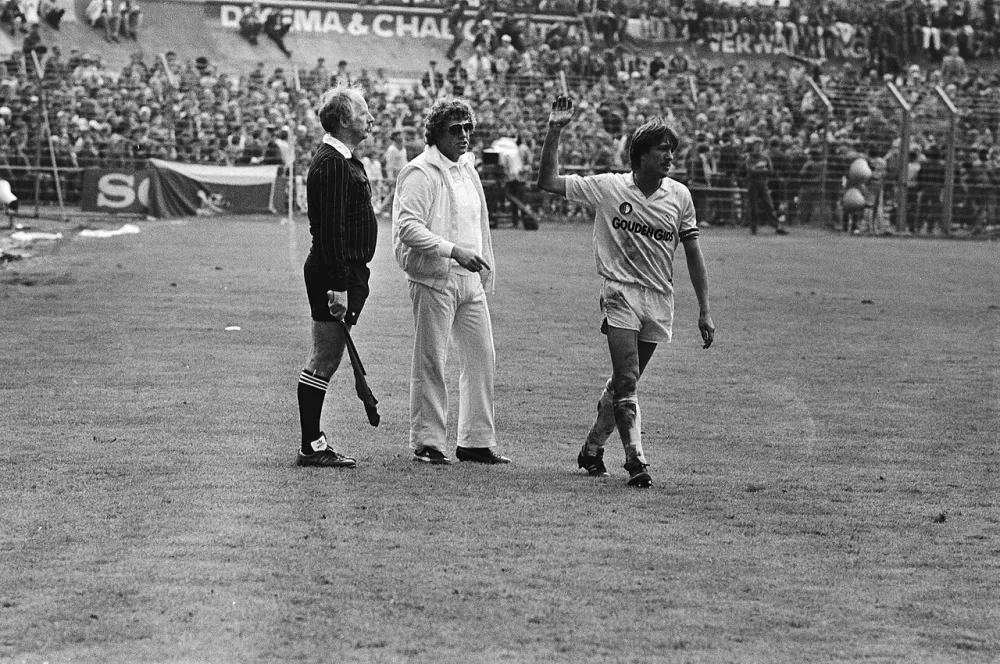 Feyenoordaanvoerder Wijnstekers maakt een "wegwerp" gebaar naar de grensrechter; in het midden verzorger Gerard Meijer van Feyenoord. Foto: Rob Bogaerts / Anefo, Nationaal Archief (CC0).