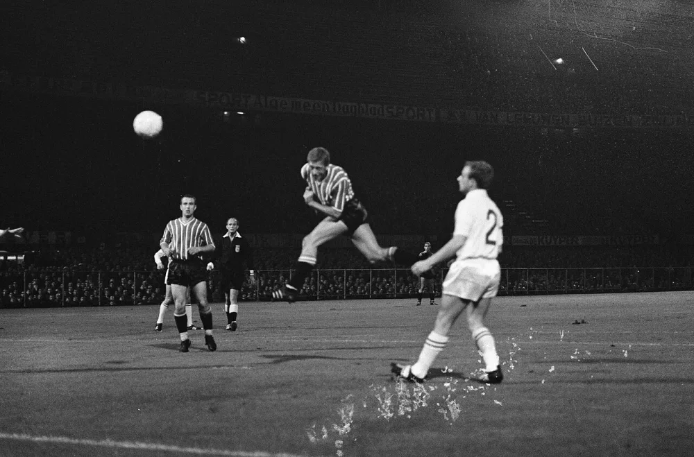 Voetbal. Vriendschappelijke wedstrijd. Feijenoord tegen Anderlecht 0-2. Kopbal van Cor van der Gijp. Links Frans Bouwmeester. Foto: Winfried Walta / Anefo, Nationaal Archief (CC0).